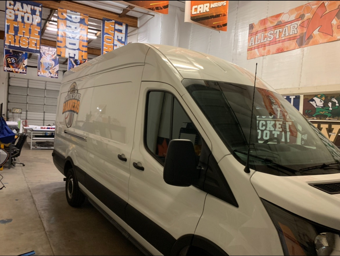Branded production van beside hanging school banners